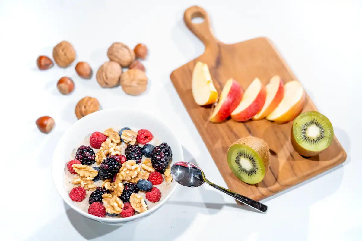 Bol cu fructe de pădure, nuci și kiwi feliat pentru o alimentație care protejează inima