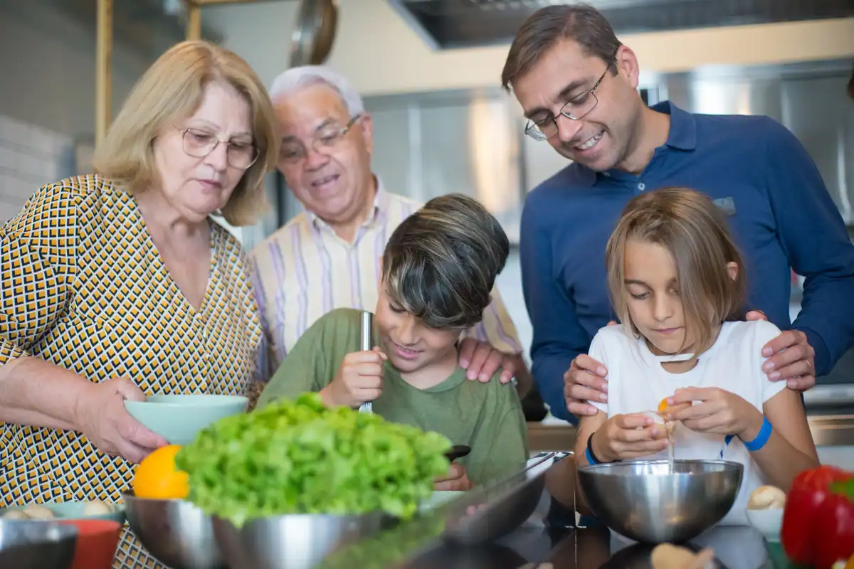 Familie din mai multe generații care pregătește împreună masa în bucătărie
