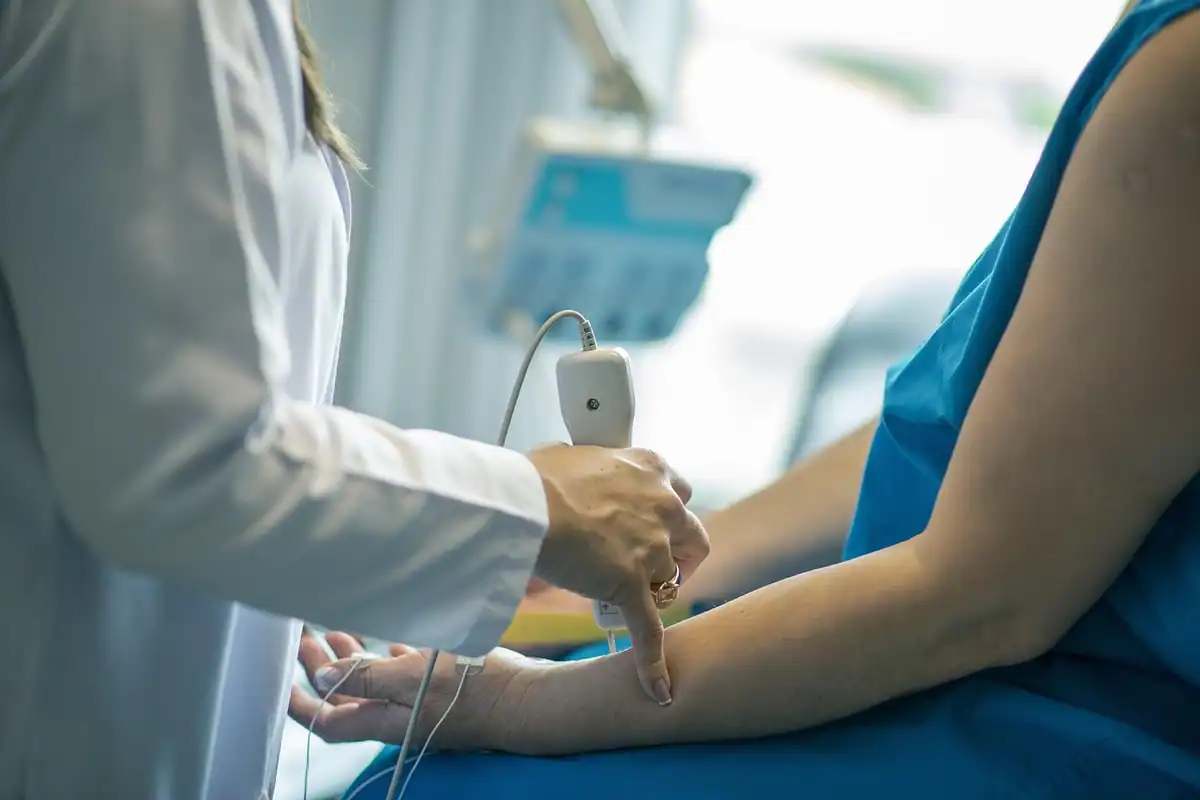 Medic care ține sonda ecografului în timpul unei examinări cu ultrasunete în cabinet