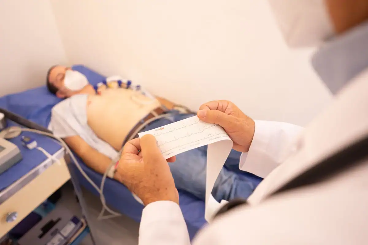 Medic care citește traseul EKG tipărit în timp ce pacientul este monitorizat