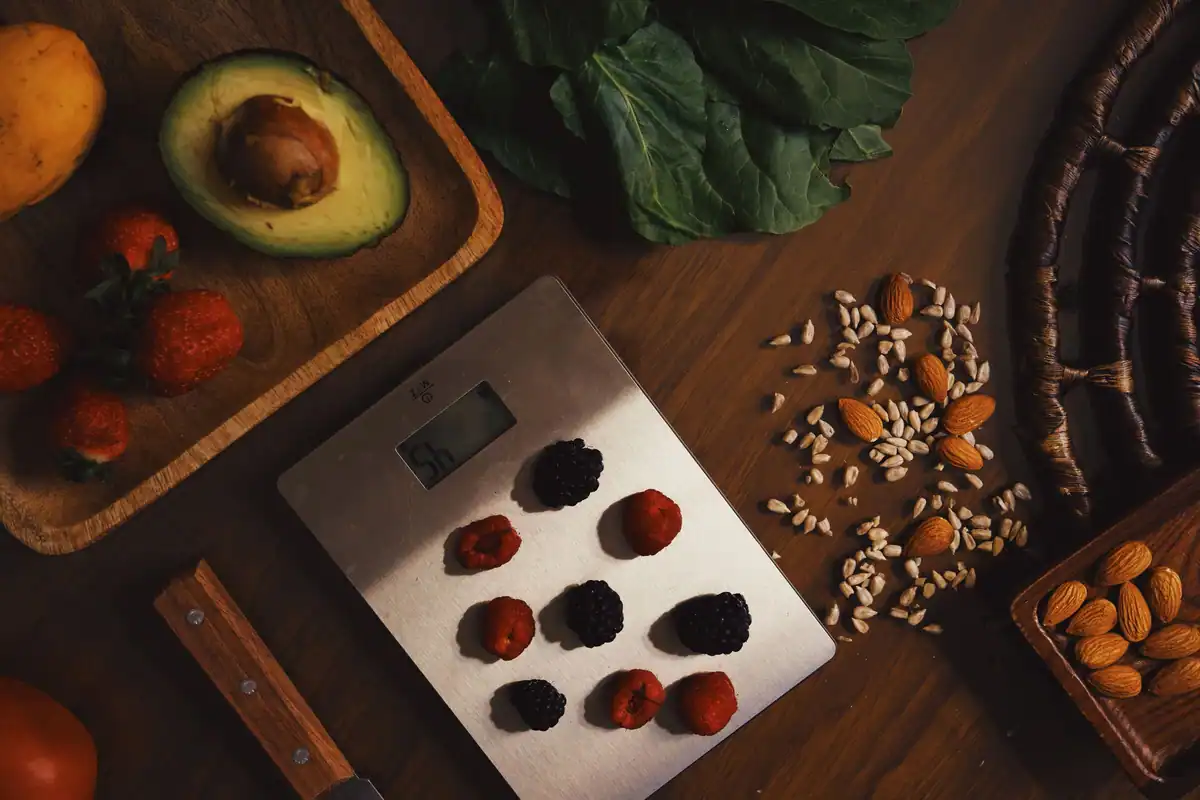 Migdale, avocado și fructe de pădure pe un cântar de bucătărie pentru o masă sănătoasă