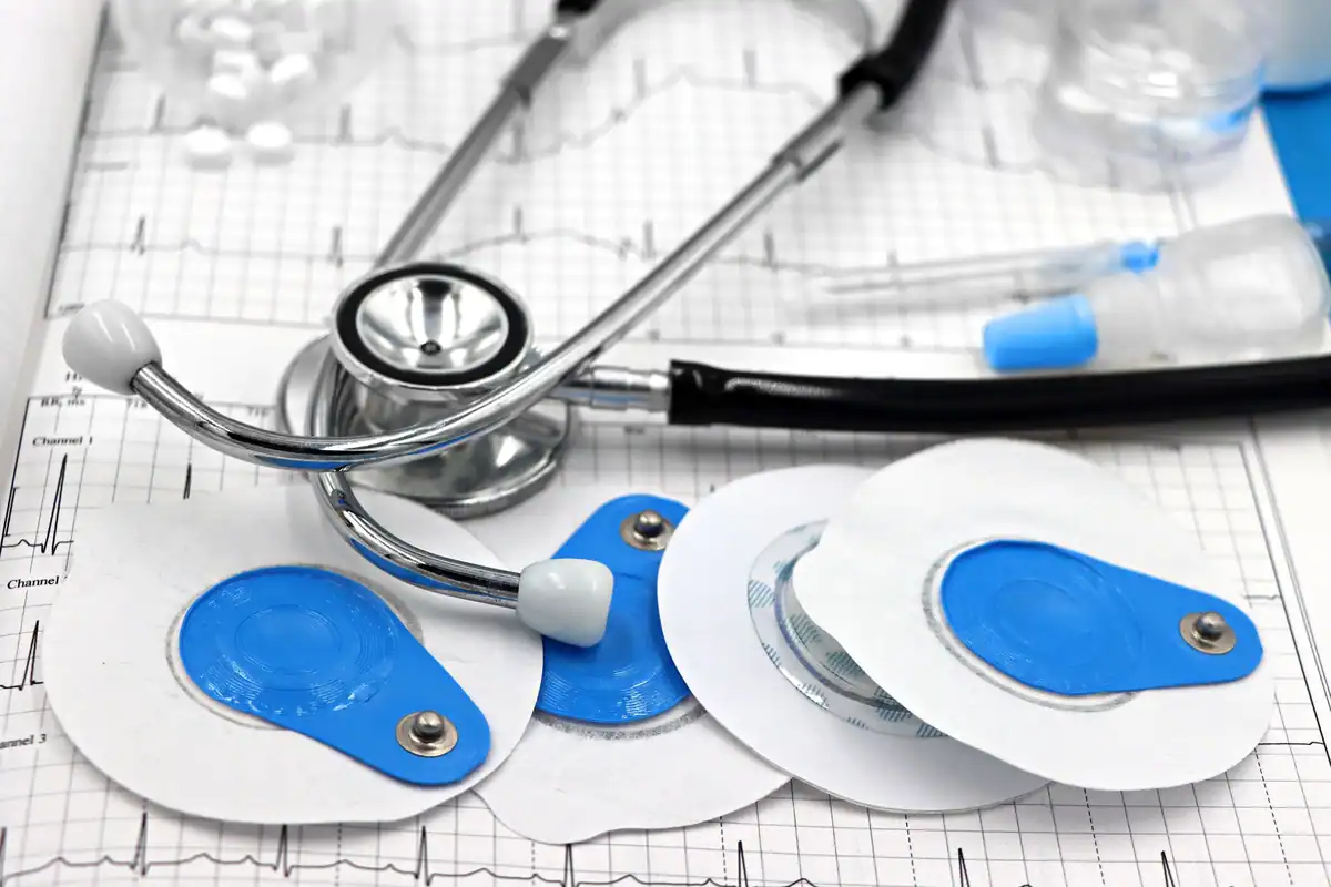 Electrozi și stetoscop așezați pe un traseu EKG tipărit