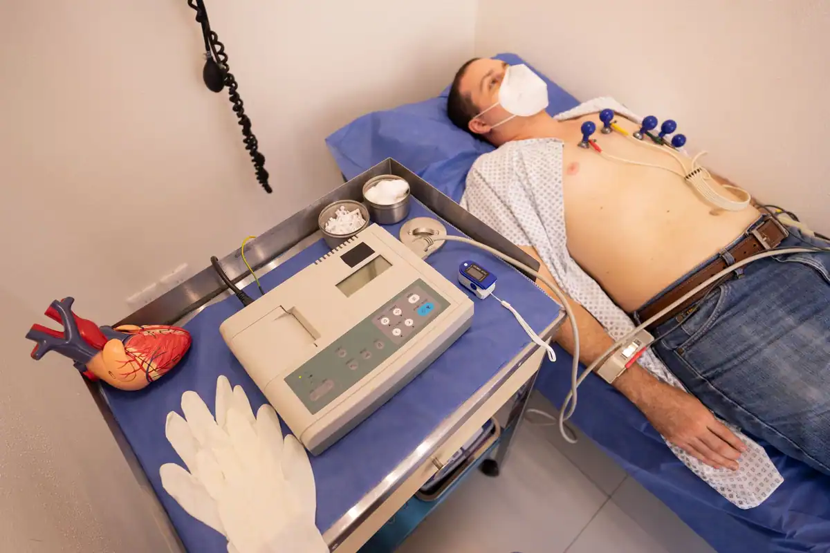 Bărbat la un consult cardiologic, conectat la aparatul EKG în clinică