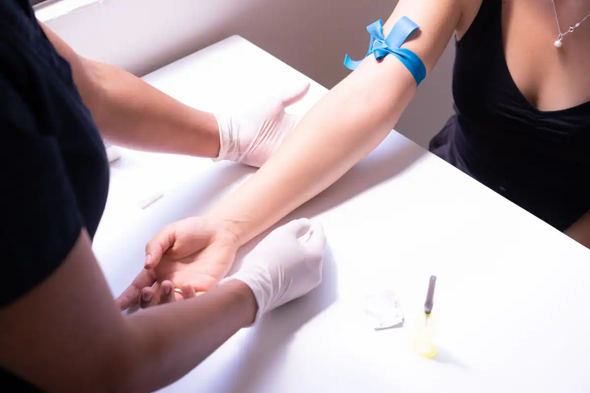 Cadru medical care recoltează sânge pentru analize într-un cabinet