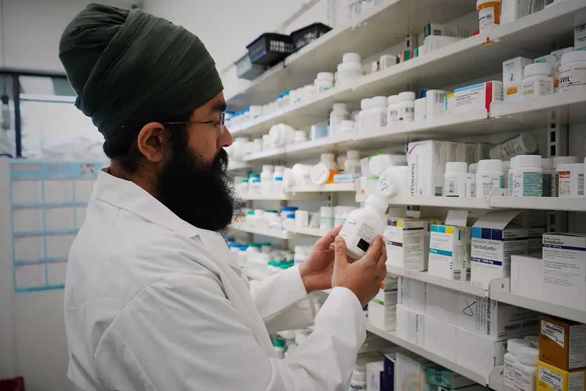Farmacist care aranjează medicamentele pe rafturile farmaciei