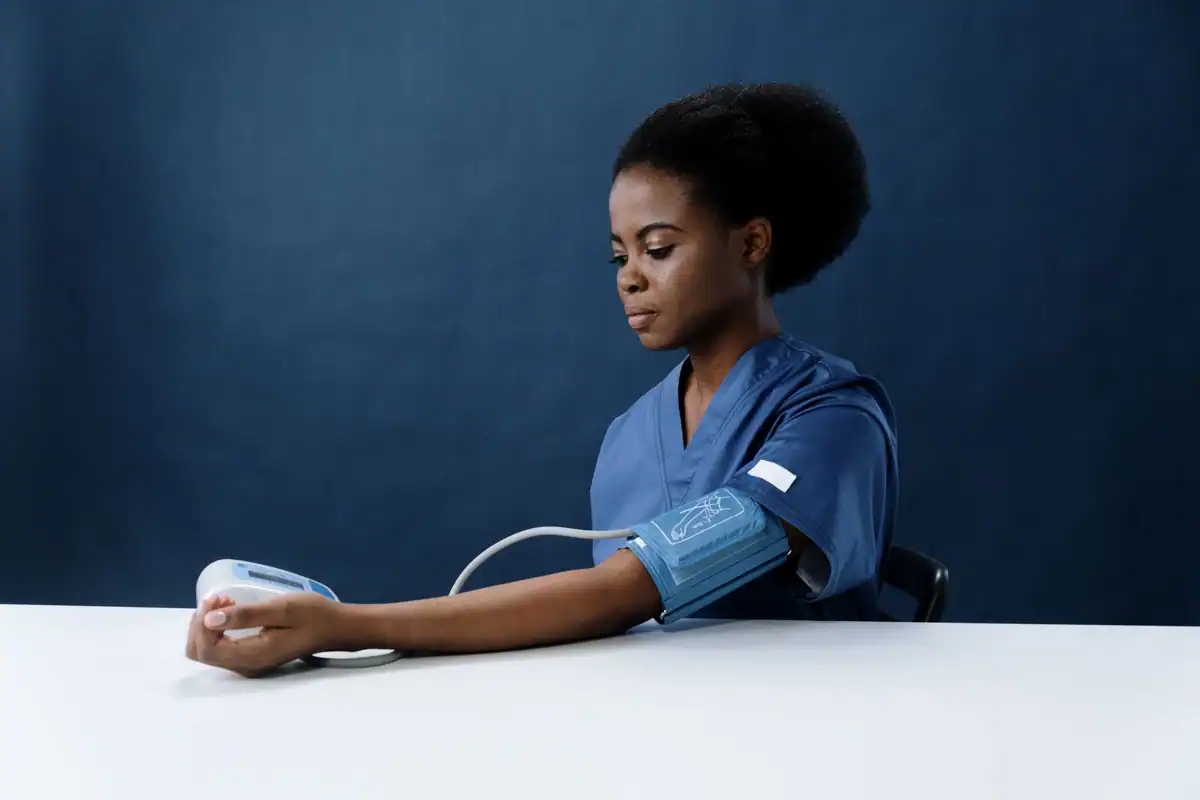 Asistentă medicală care măsoară tensiunea arterială a unui pacient